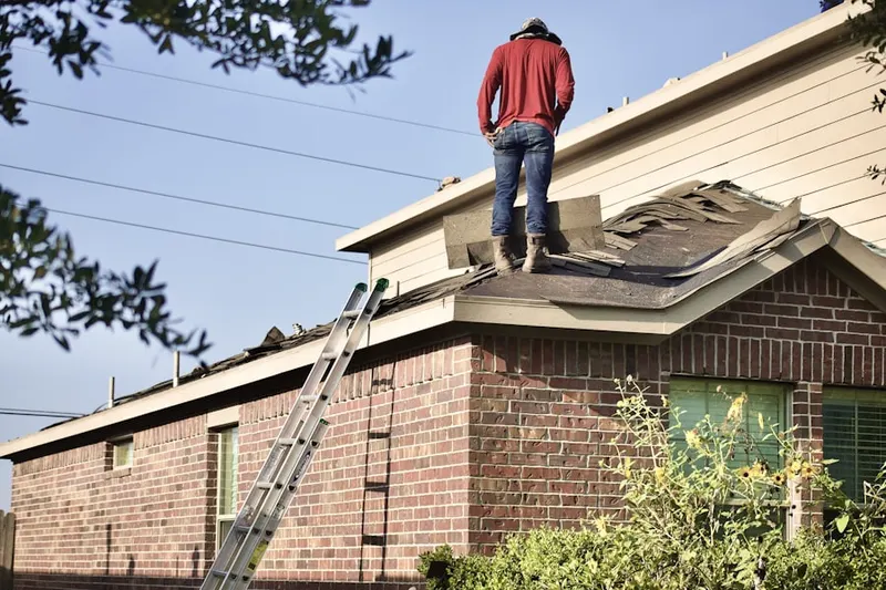 Professional roofer working on a residential roof in Booneville